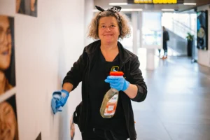 En lokalvårdare rengör en vägg